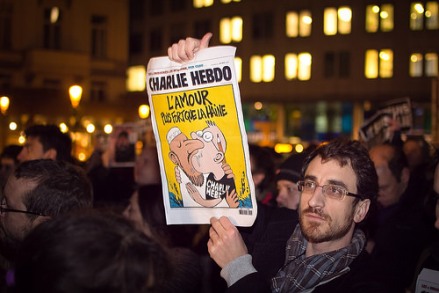 Manifestante con una portada de Charlie Hebdo "El amor es más fuerte que el odio". 